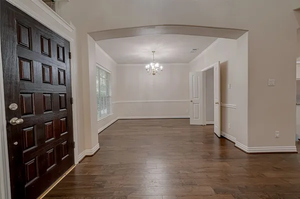 wooden floor in an empty room with a kitchen