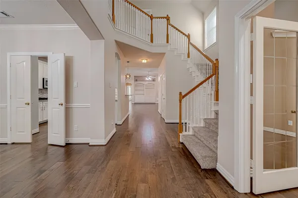 a view of a hallway with wooden floor and staircase