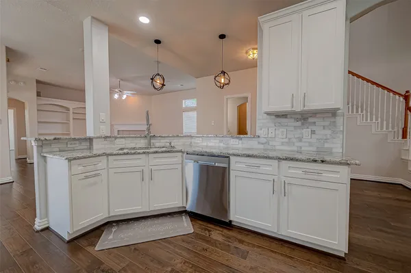 a kitchen with a sink cabinets and wooden floor