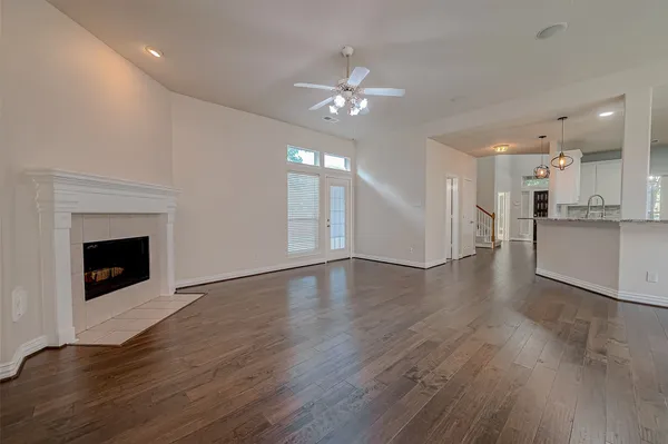 a view of a livingroom with a fireplace a chandelier and wooden floor