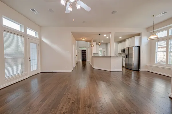 an empty room with wooden floor and windows