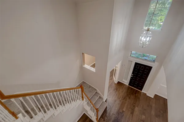 a view of a hallway with wooden floor and staircase