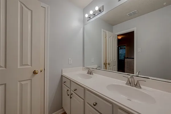 a bathroom with a double vanity sink and a mirror