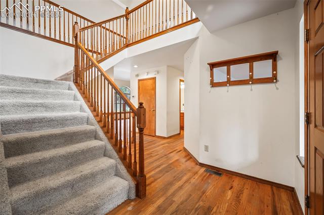 8180 Tannenbaum Road Colorado Springs, CO 80908 - Photo 7 of 11 Entryway featuring a towering ceiling and wood flooring