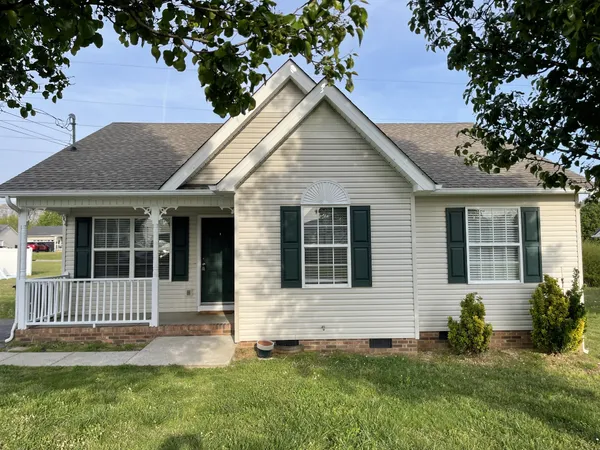 a front view of a house with a yard and trees