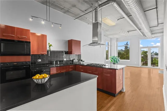 a kitchen with stainless steel appliances granite countertop a sink and a stove