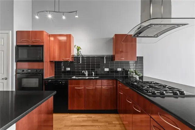 a kitchen with stainless steel appliances granite countertop a sink stove and refrigerator