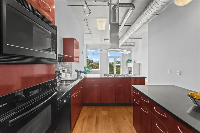 a kitchen with stainless steel appliances granite countertop a sink and a stove