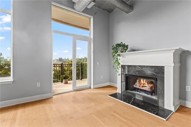 a living room with a fireplace with a floor to ceiling window