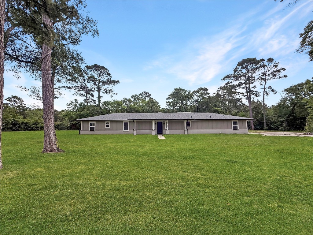 a view of a yard in front of a house with large trees