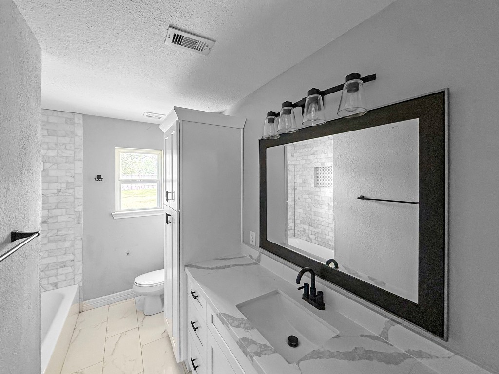 3706 Roberts Boulevard Baytown, TX 77521 - Photo 14 of 22 a bathroom with a sink a mirror and a toilet