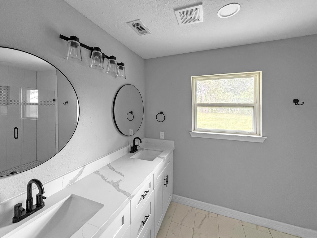 3706 Roberts Boulevard Baytown, TX 77521 - Photo 17 of 22 a bathroom with a double vanity sink and a mirror