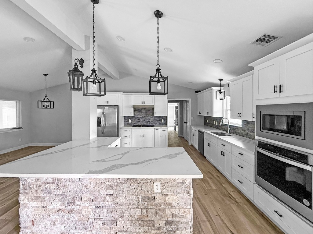 3706 Roberts Boulevard Baytown, TX 77521 - Photo 5 of 22 a large kitchen with kitchen island a stove a sink a center island and wooden floor