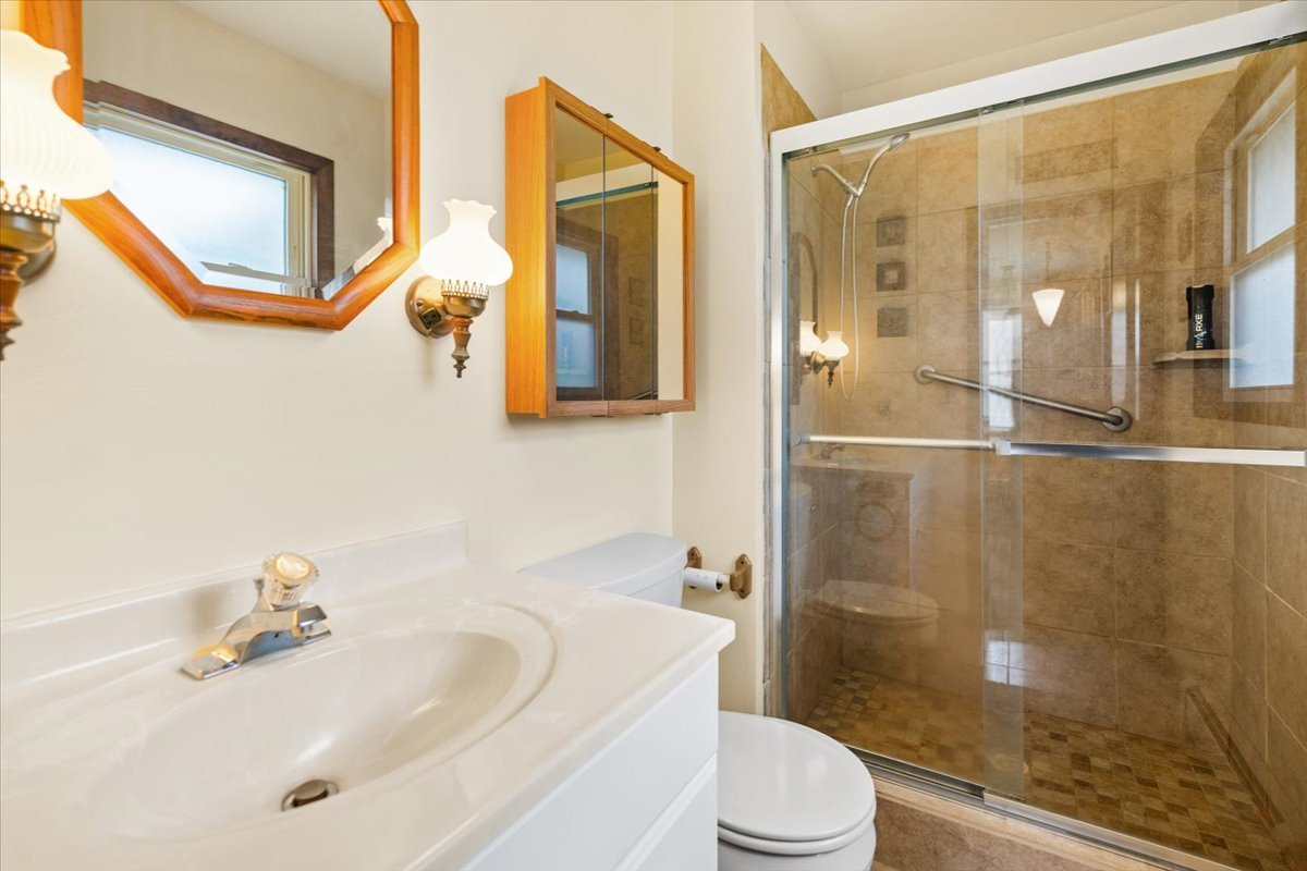 7112 Altenburg Road Harvard, IL 60033 - Photo 15 of 26 a bathroom with a sink mirror toilet and shower