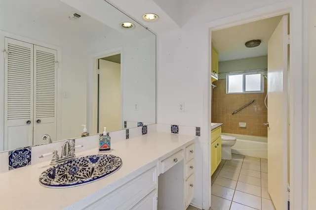 a bathroom with a granite countertop sink toilet and shower