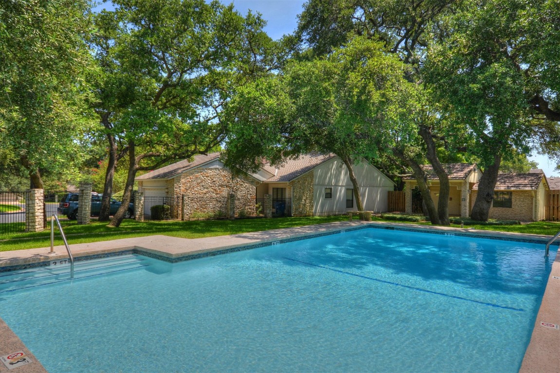 8151 Meandering Way Austin, TX 78759 - Photo 20 of 23 a view of a white house with a big yard and large trees