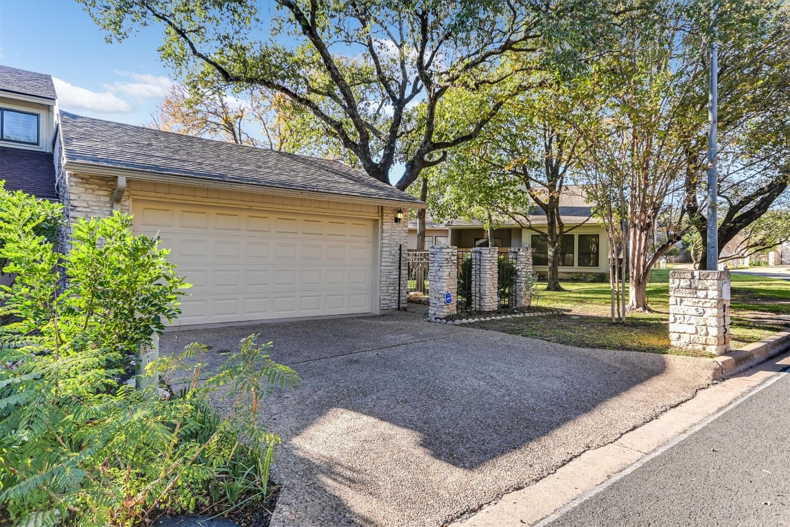 8151 Meandering Way Austin, TX 78759 - Photo 2 of 23 a view of a yard with plants and large tree