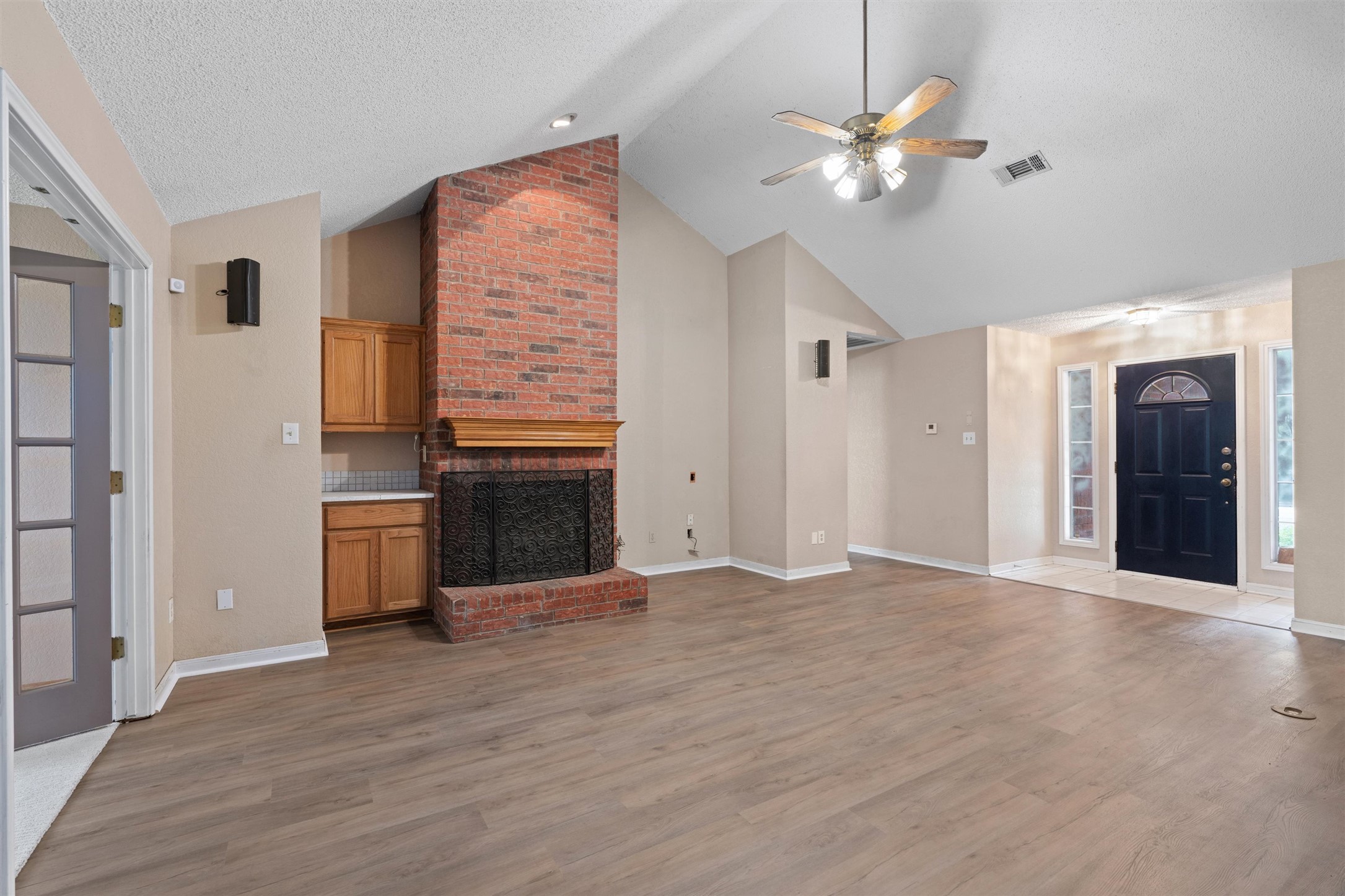 2306 Raintree Path Round Rock, TX 78664 - Photo 4 of 23 A striking brick fireplace grounds this spacious living area with vaulted ceilings and wood flooring.