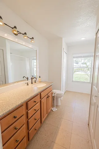 a spacious bathroom with a granite countertop sink a mirror and a bathtub