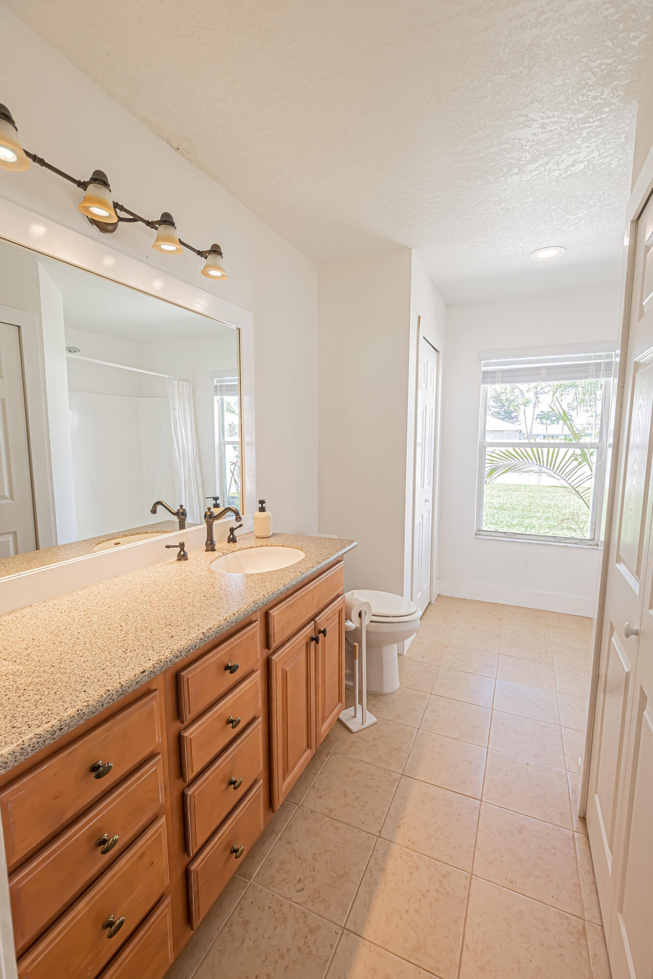 526 Southwest Dairy Road Port St. Lucie, FL 34953 - Photo 9 of 23 a spacious bathroom with a granite countertop sink a mirror and a bathtub