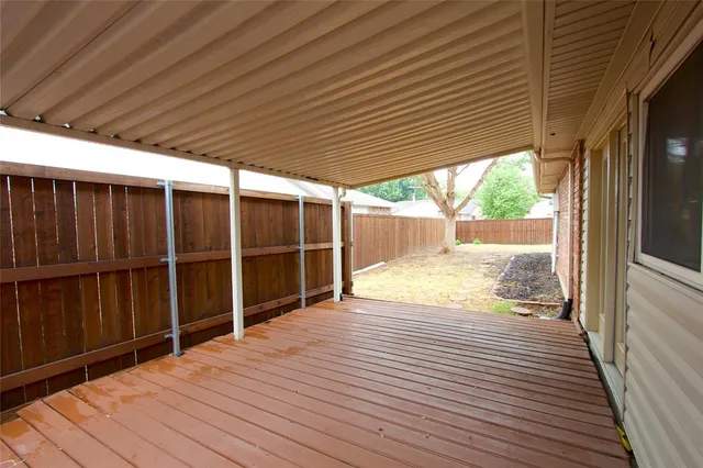 a view of empty room with wooden floor and floor to ceiling window