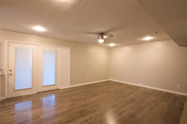 a view of an empty room with wooden floor