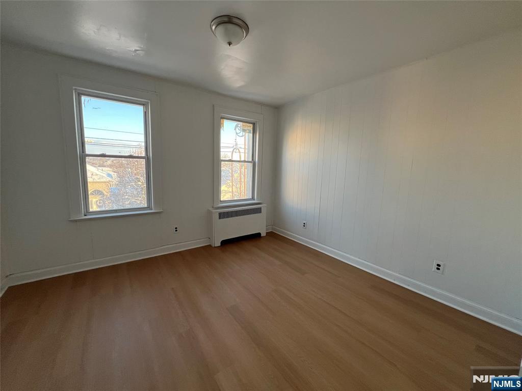159 Westminster Place, Unit 5 Lodi, NJ 07644 - Photo 3 of 5 an empty room with wooden floor and windows
