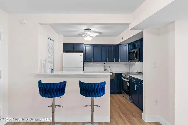 a kitchen with stainless steel appliances a stove a sink and a refrigerator