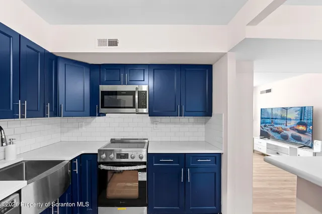 a kitchen with stainless steel appliances wooden cabinets and a stove top oven
