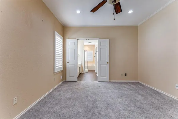 an empty room with ceiling fan and window