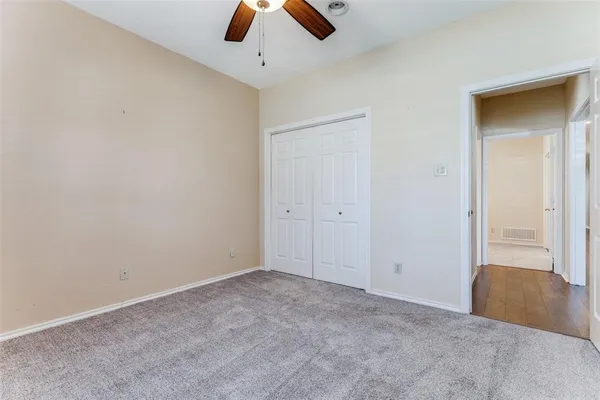an empty room with closet and chandelier fan
