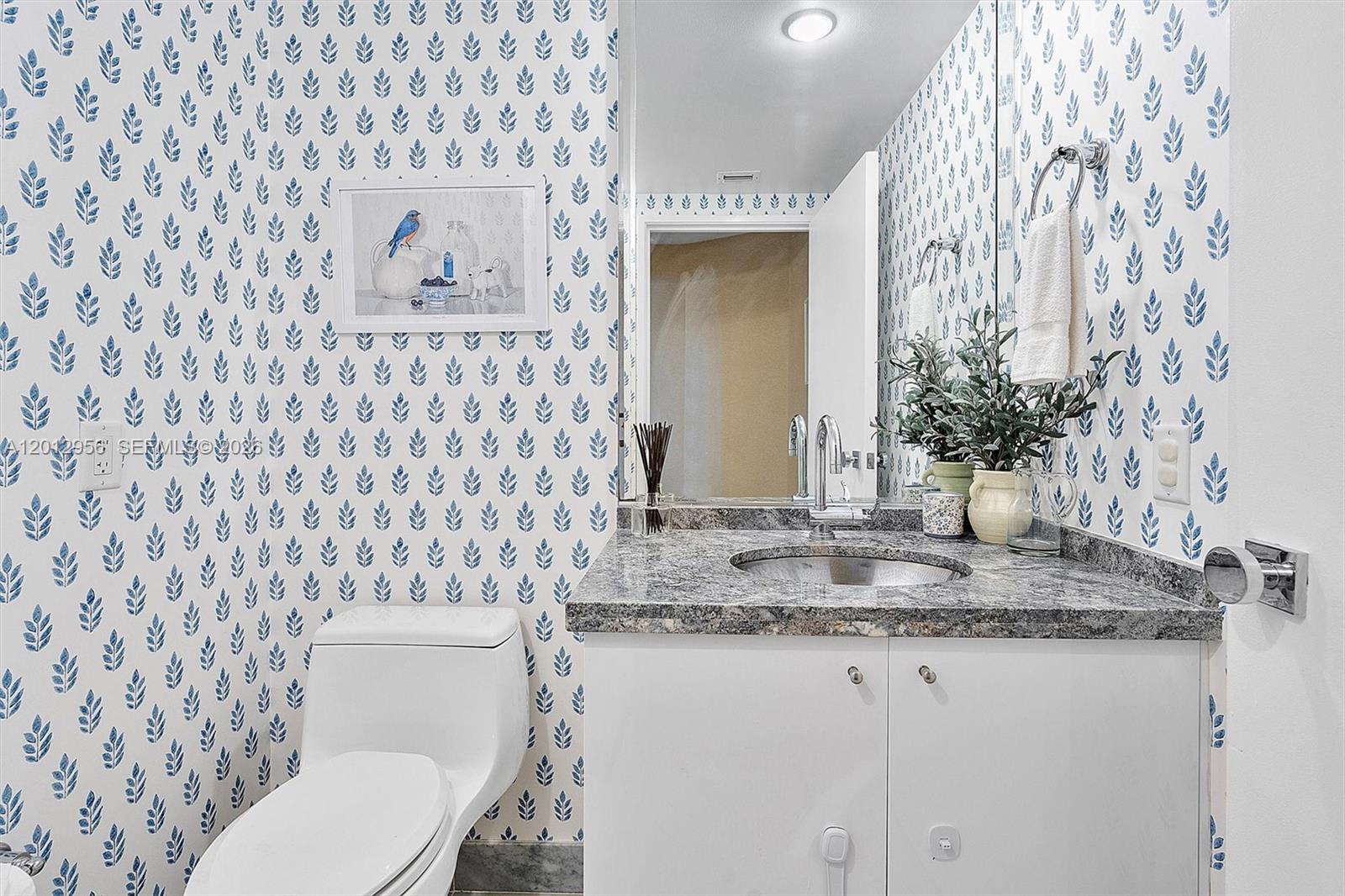 9401 Collins Avenue, Unit 505 Surfside, FL 33154 - Photo 13 of 39 a bathroom with a granite countertop sink and a toilet