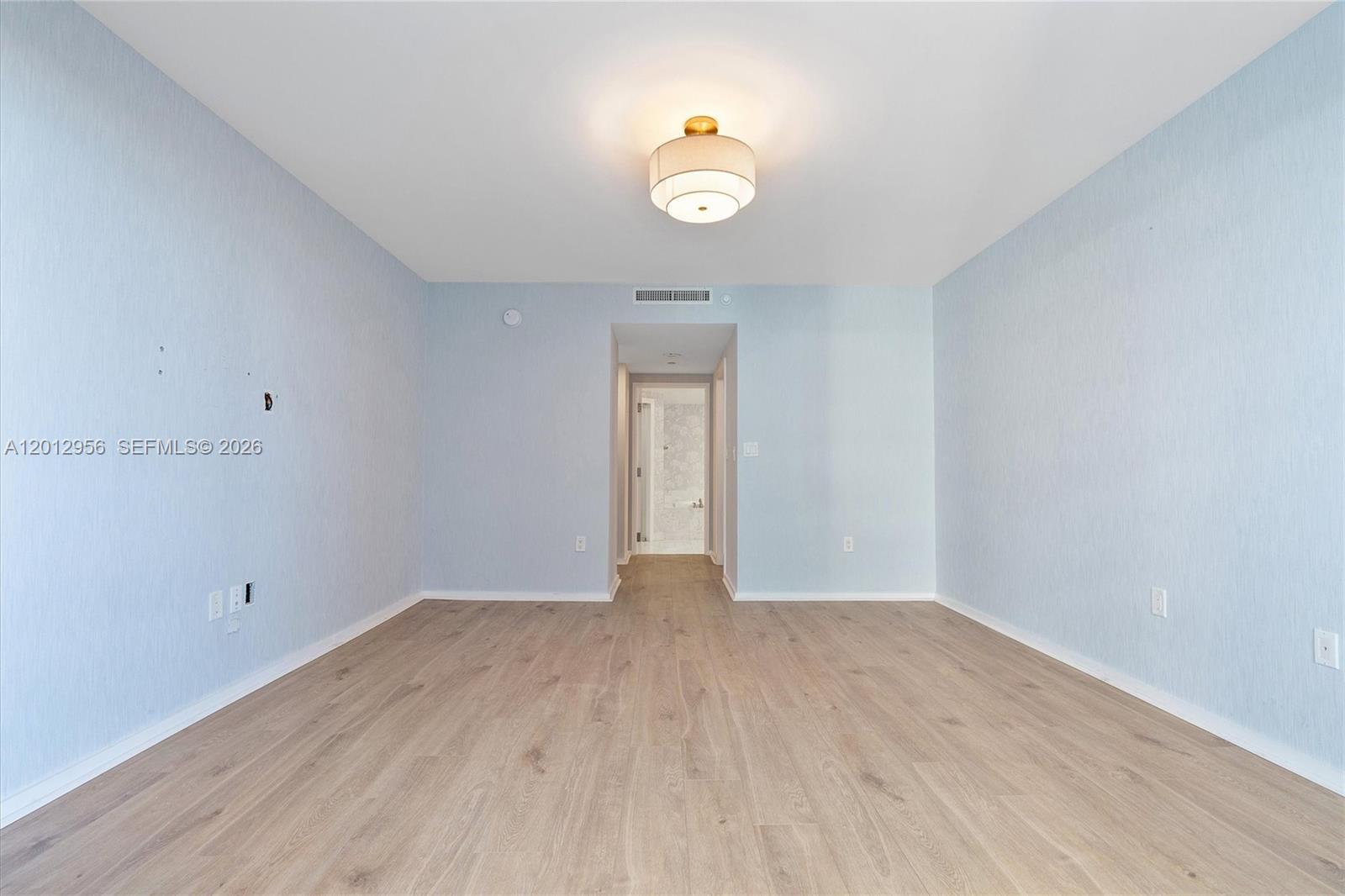 9401 Collins Avenue, Unit 505 Surfside, FL 33154 - Photo 18 of 39 a view of an empty room with wooden floor and window