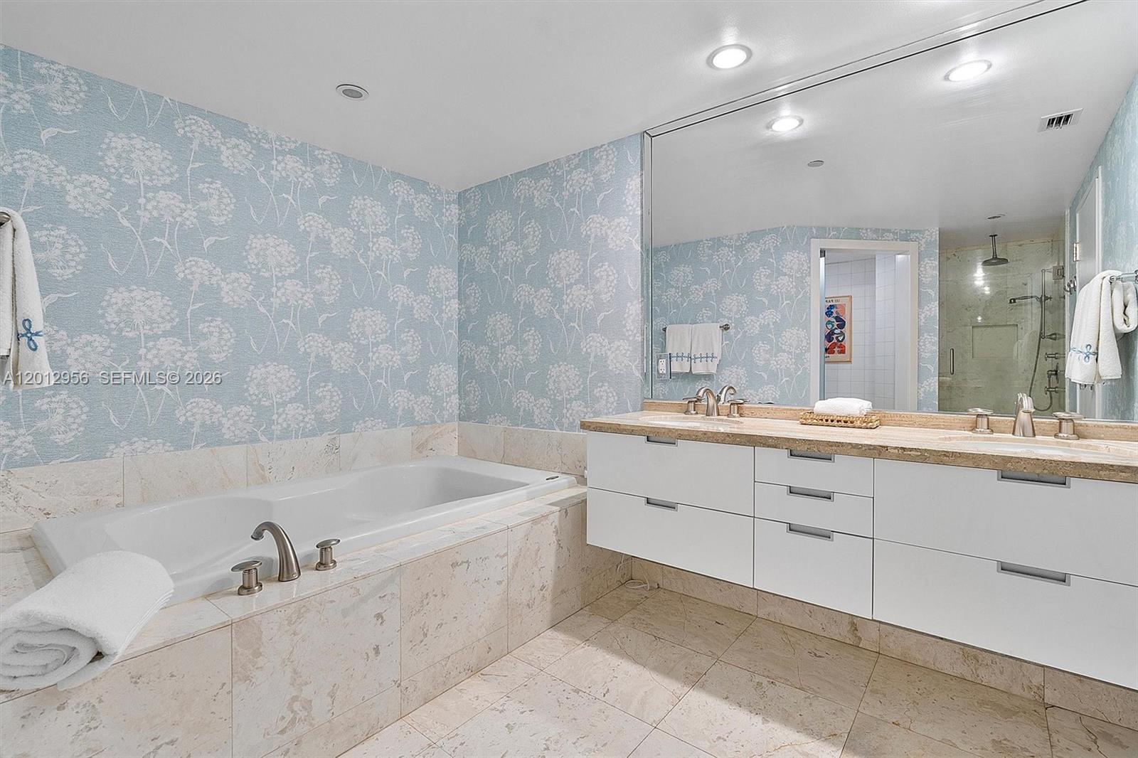 9401 Collins Avenue, Unit 505 Surfside, FL 33154 - Photo 19 of 39 a bathroom with a tub sink and mirror
