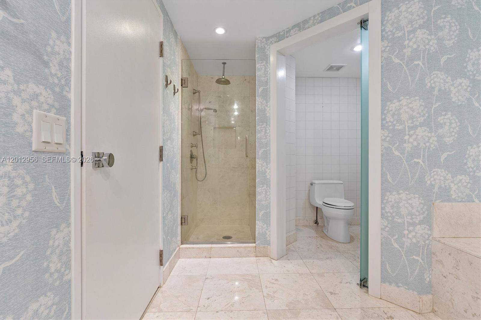 9401 Collins Avenue, Unit 505 Surfside, FL 33154 - Photo 20 of 39 a bathroom with a toilet sink and shower