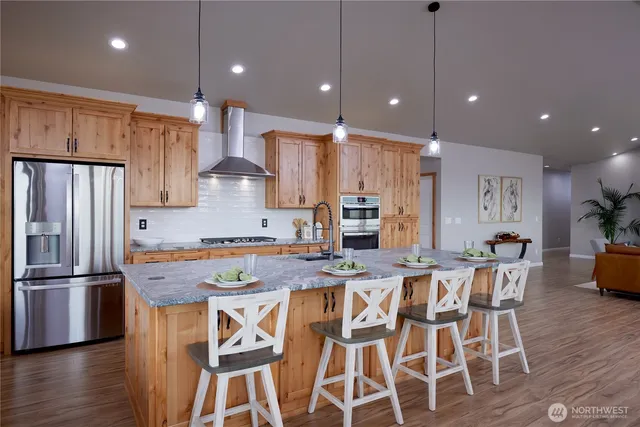 a kitchen with stainless steel appliances granite countertop a stove refrigerator a table and chairs