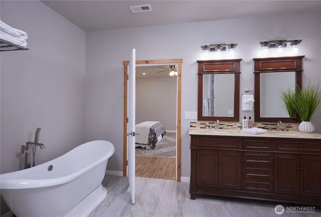 a bathroom with a granite countertop sink a toilet and mirror