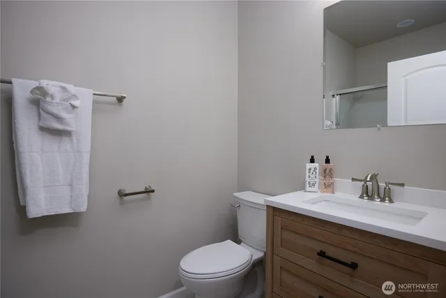 a bathroom with a toilet sink vanity and mirror