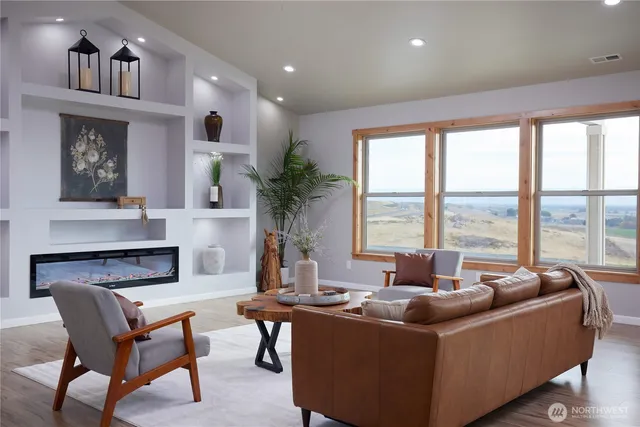 a living room with furniture fireplace and a large window