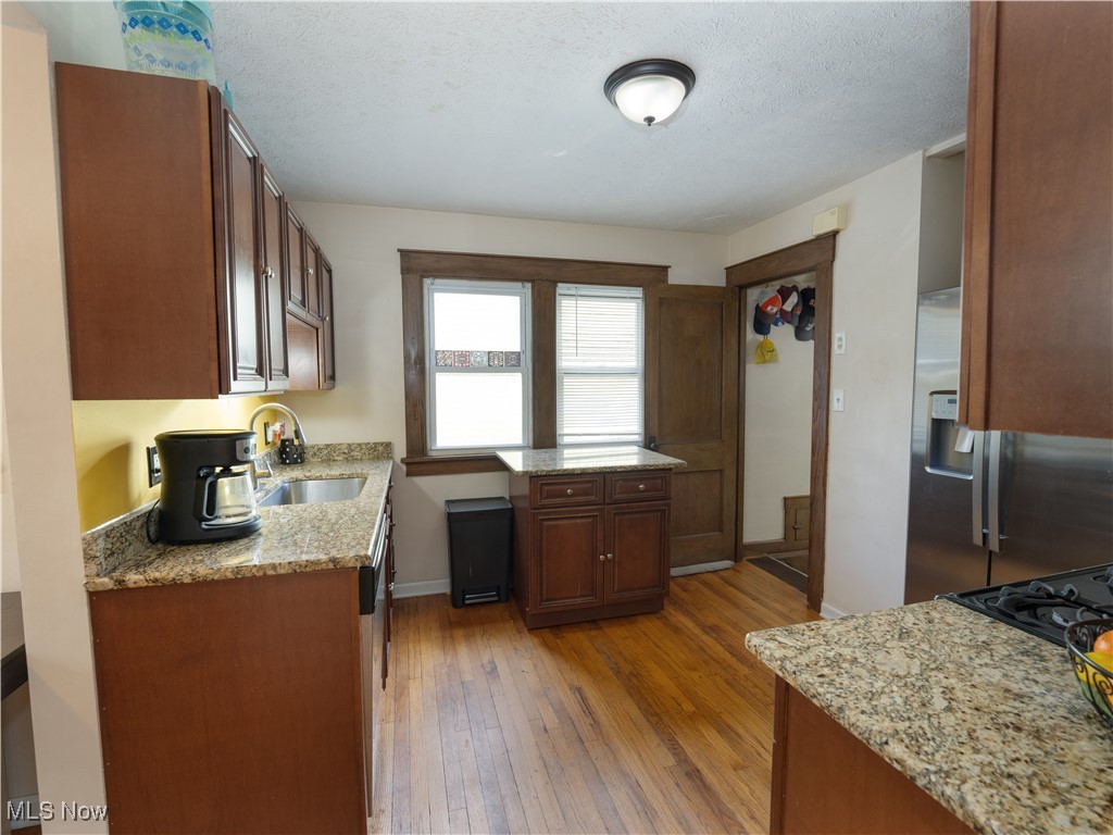 6021 Snow Road Parma, OH 44129 - Photo 7 of 28 Kitchen featuring granite countertops, stainless steel refrigerator with ice dispenser, wood flooring and plenty of cabinetry