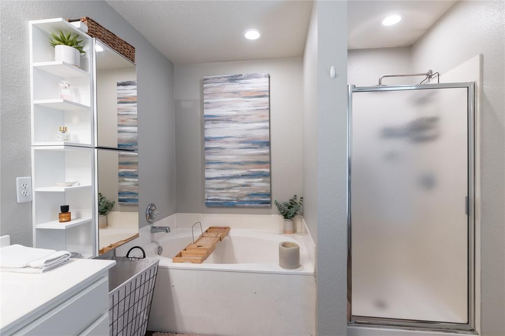 201 South Sumac Lane Georgetown, TX 78633 - Photo 11 of 15 Bathroom featuring vanity, a shower stall, a garden tub, and a textured wall