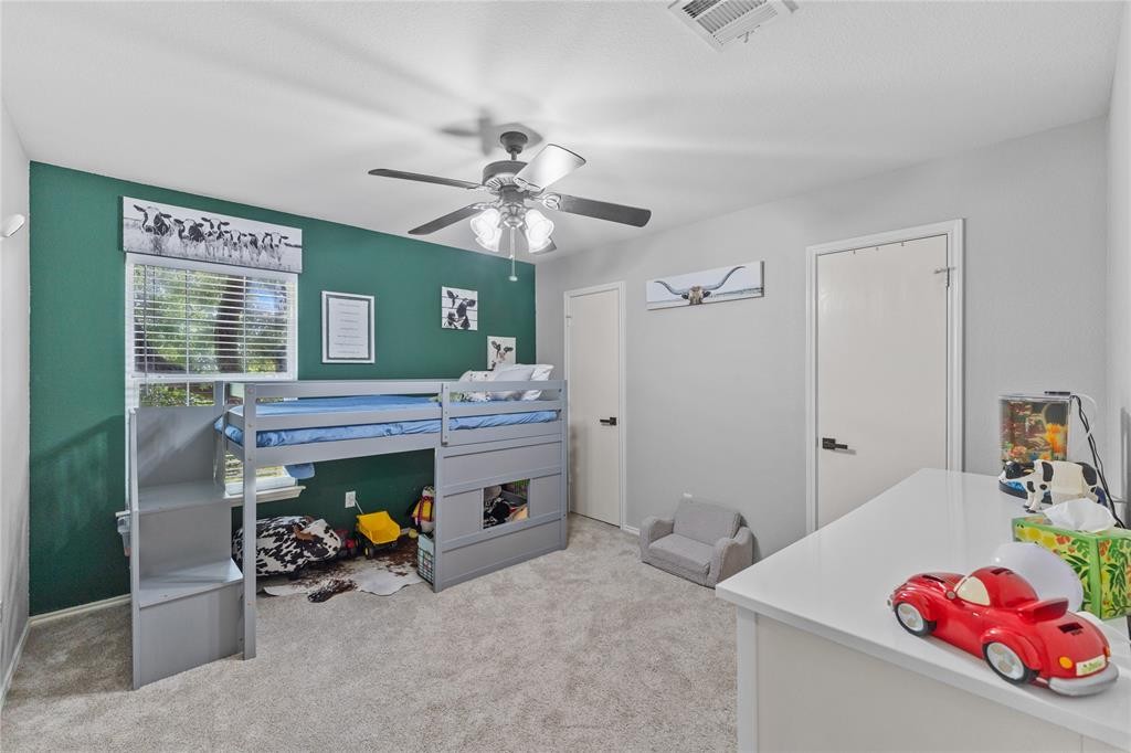201 South Sumac Lane Georgetown, TX 78633 - Photo 12 of 15 Bedroom with light colored carpet and ceiling fan