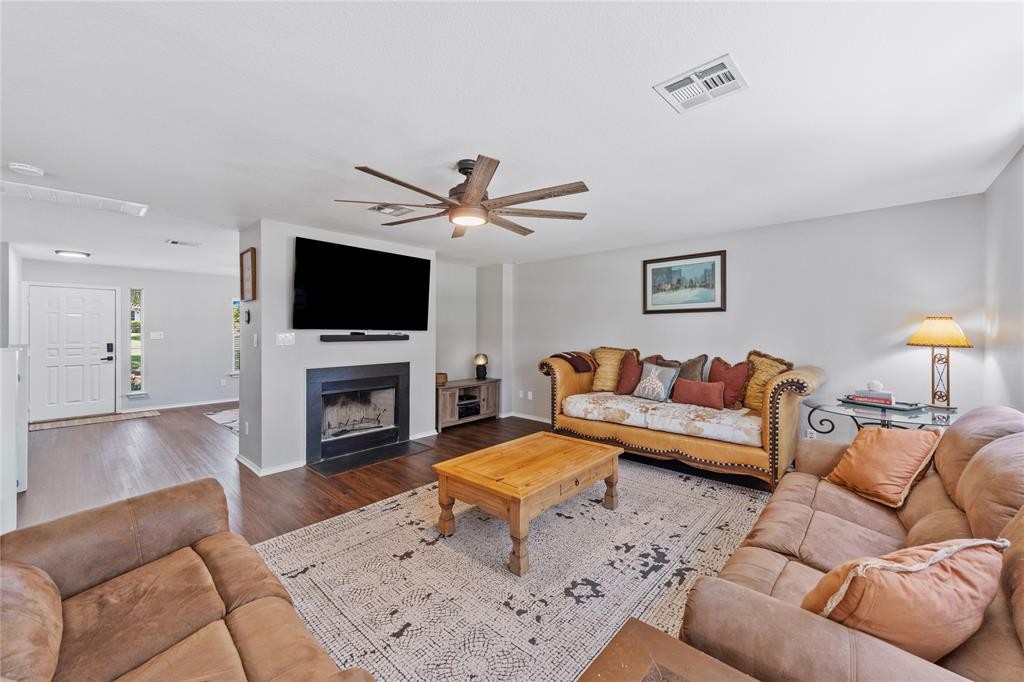 201 South Sumac Lane Georgetown, TX 78633 - Photo 3 of 15 Living area with a fireplace with flush hearth, a ceiling fan, and wood finished floors