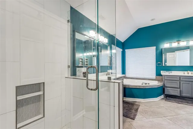 a bathroom with a tub sink and mirror