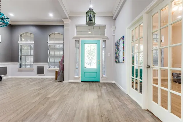 a view of a hallway with wooden floor and windows