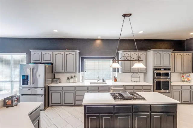 a kitchen with stainless steel appliances kitchen island a sink stove and refrigerator