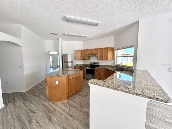 a kitchen with stainless steel appliances granite countertop a sink stove and refrigerator