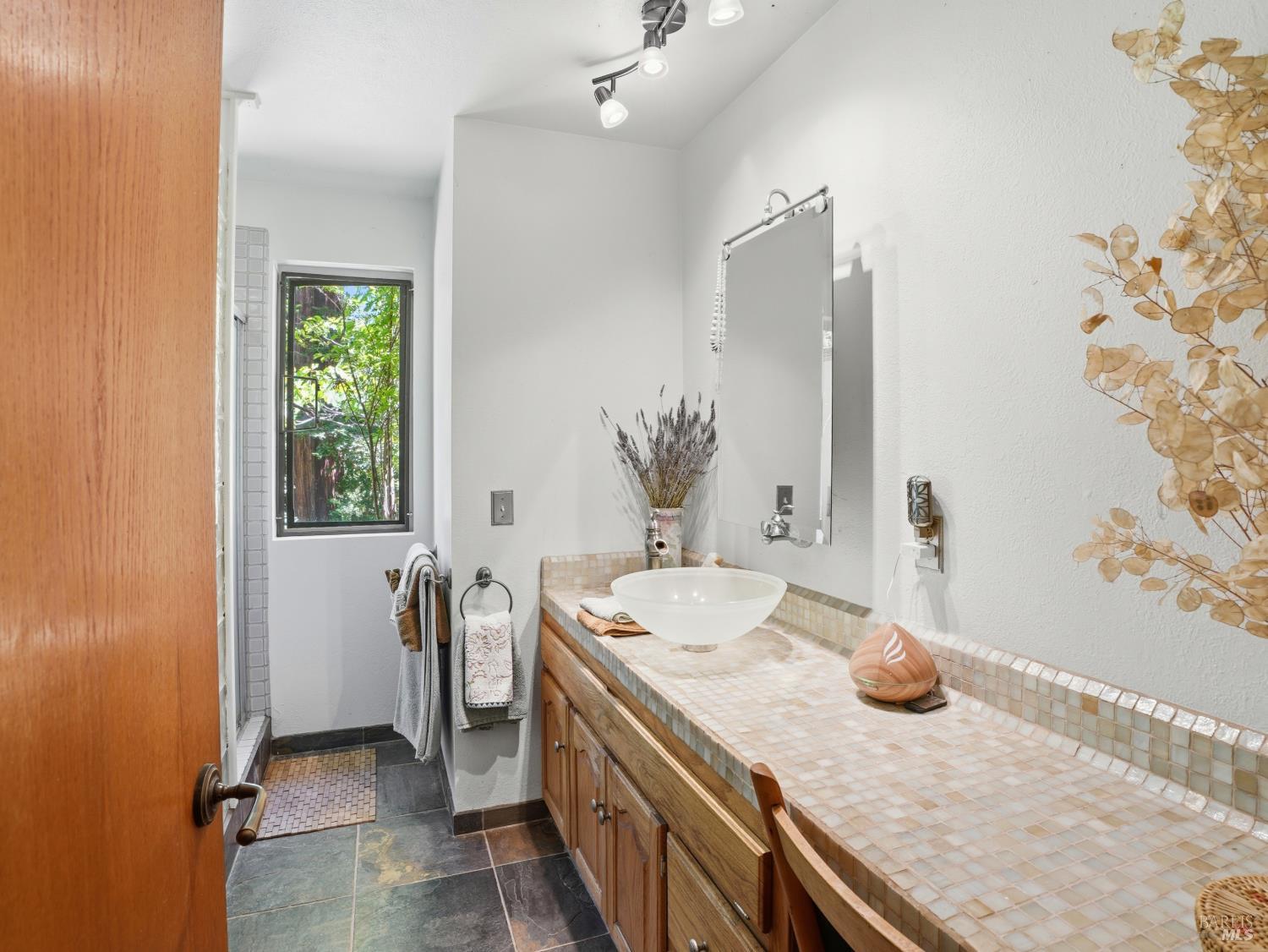 31397 Seaview Road Cazadero, CA 95421 - Photo 22 of 47 a spacious bathroom with a granite countertop sink a mirror and a shower