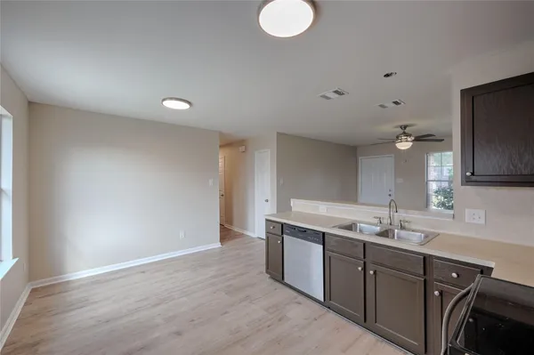 a kitchen with a sink cabinets and wooden floor