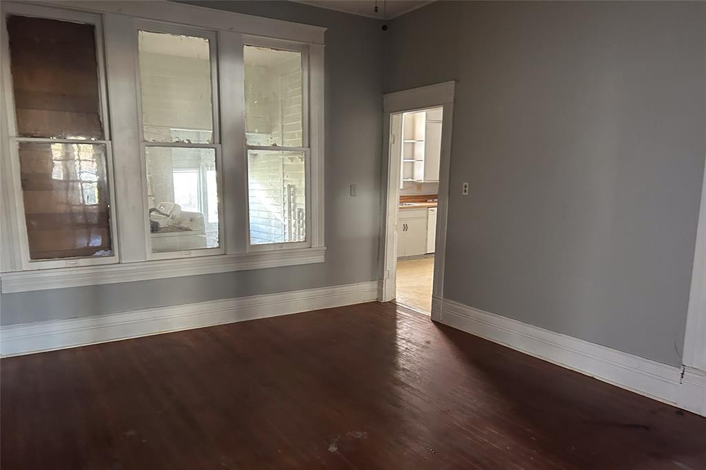 701 South Clements Street Gainesville, TX 76240 - Photo 21 of 28 an empty room with wooden floor and windows